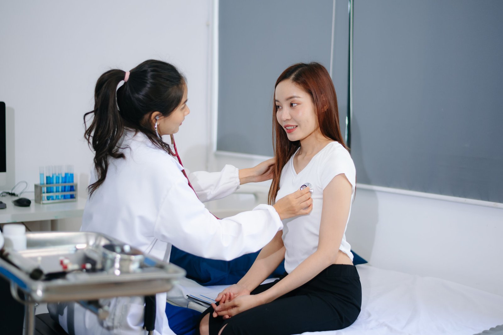 asian doctor and patient discussing something while sitting at t