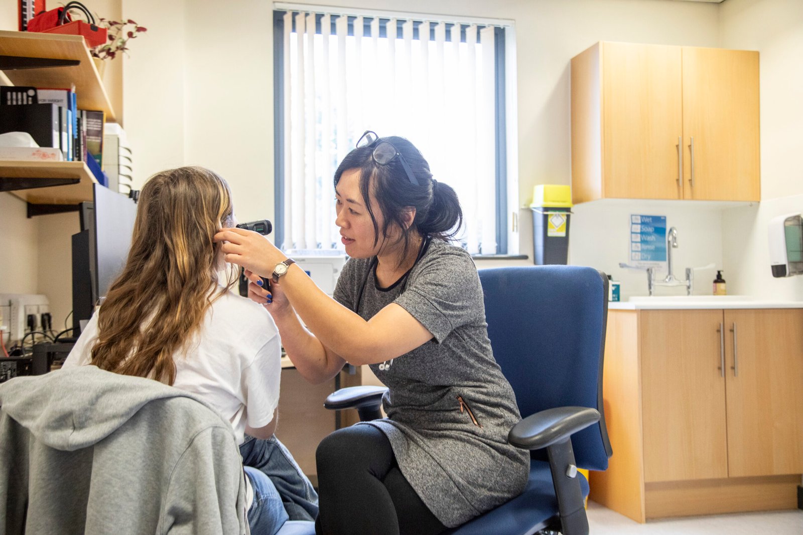medical professional conducting an ear examination on a patient.
